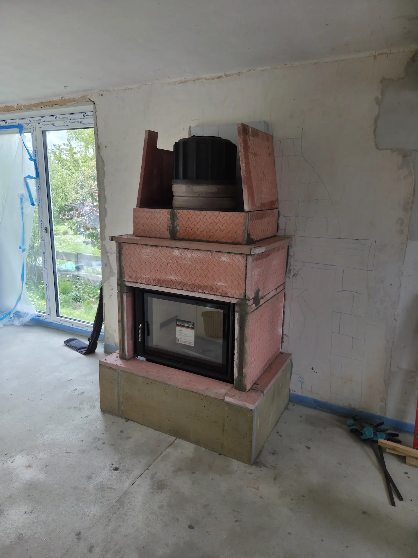 Brunner HKD 7 mit Aufsatzspeicher und Brula-Platten, daneben das an die Wand gezeichnete Steinbild